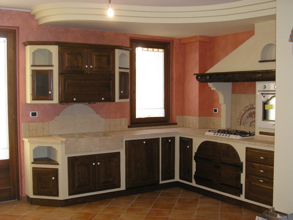 Foto di cucina con mattenelle beige, cassetti in legno scuro e parete rosa.